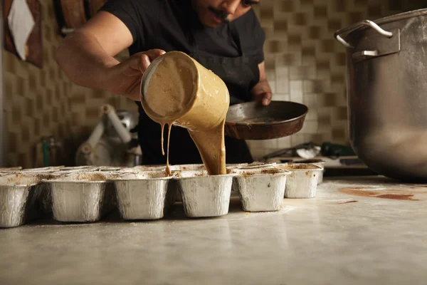 Man pours liquid cake batter from measure cup — Stock Photo, Image