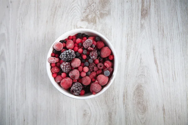 Frozen berries in white bowl — Stockfoto