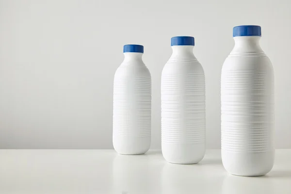 Белые пластиковые бутылки с голубыми колпачками — стоковое фото