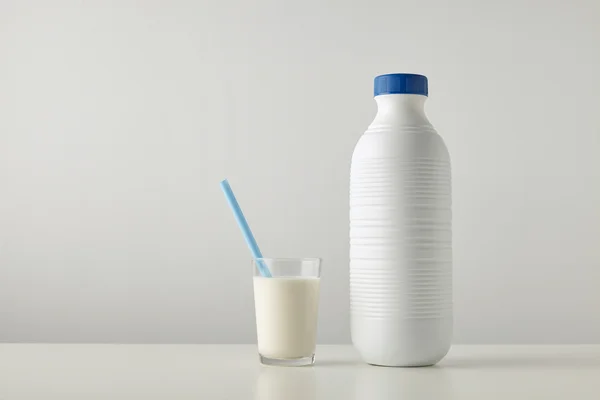 Glass with organic milk near plastic bottle — Stock Photo, Image