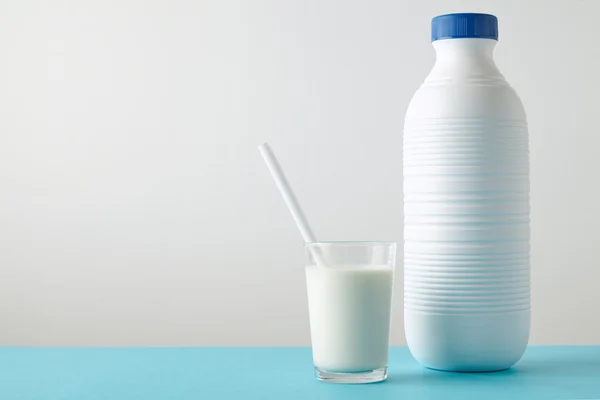 Стекло с органическим молоком возле пластиковой бутылки — стоковое фото