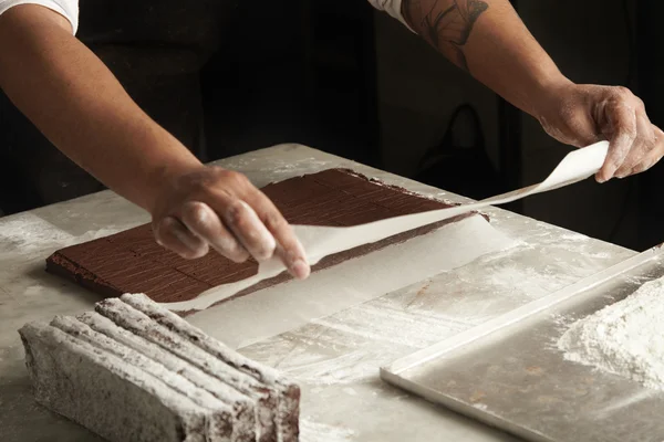 Člověk vaří čokoládové koláče — Stock fotografie