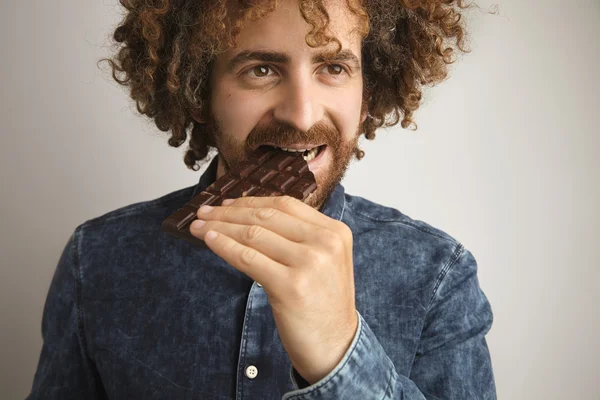 Hombre muerde barra de chocolate casero — Foto de Stock