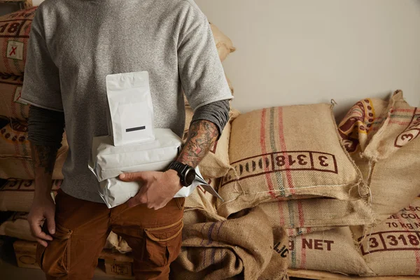 Barista má tašky s čerstvě upečenými kávovou fazolí — Stock fotografie