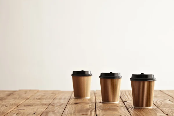 Three carton paper cups in row — Stock Photo, Image