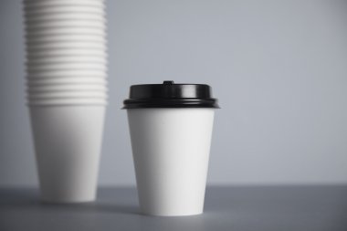 white paper cup with black cap 