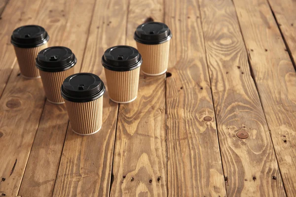 Cinco copos de papel da caixa com tampas pretas — Fotografia de Stock