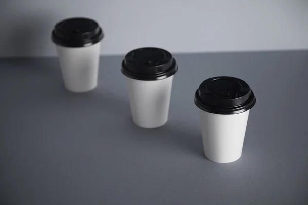 Три візьміть білі паперові чашки — стокове фото