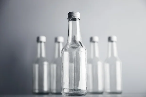 Bouteille en verre vide devant d'autres non concentrés — Photo