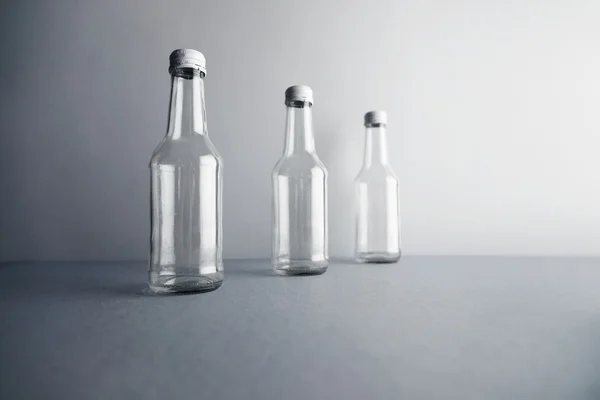 Trois bouteilles en verre scellées vides pour les boissons — Photo