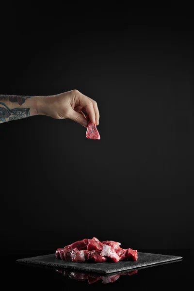 Butcher hand takes piece of raw fresh meat — Stock Photo, Image