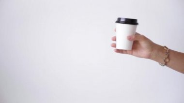 Woman hand gives white paper cup to man