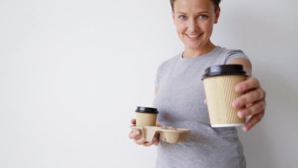 Femme présente tasse en papier sur la caméra — Video