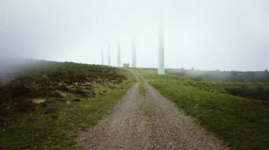 wind turbine towers hidden in thick fog