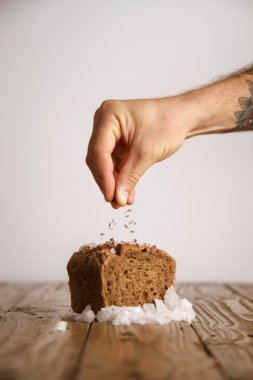 Dövmeli el ekmek üzerine lavanta tohumu döker 
