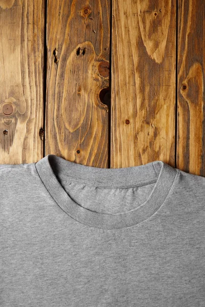 Ahşap masa üzerinde boş gri t-shirt — Stok fotoğraf