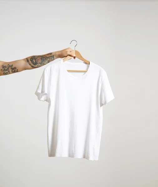 Hand houdt hangen met wit t-shirt — Stockfoto