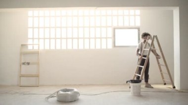 adam merdiven ve boyalar getiriyor ve iş bakmak