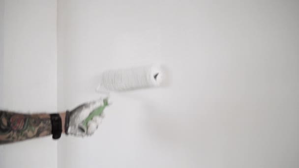 Tätowierte Hand bemalt die Wand mit Pinselwalze — Stockvideo