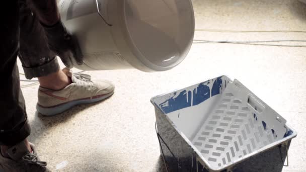 Man pours white paint to blue container — Stock Video