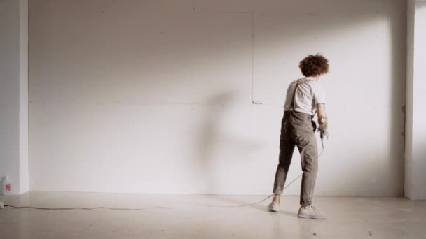 Hombre pone tornillos dentro de la pared de yeso — Vídeo de stock