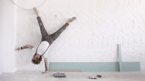 Man målar vägg och en hand huvud stativ — Stockvideo