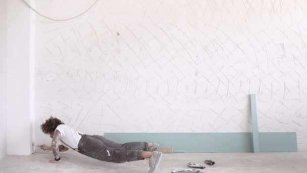 Hombre pintura pared y una mano flexiones — Vídeos de Stock