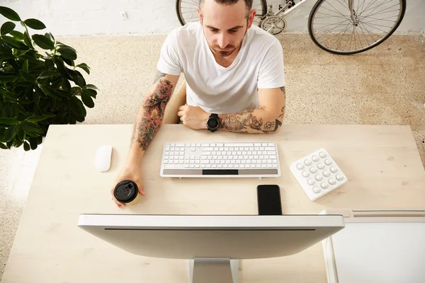 Freelance tiene il caffè e guardando su computer — Foto Stock