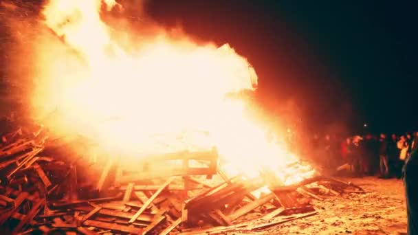 Люди смотрят большой огромный огонь — стоковое видео