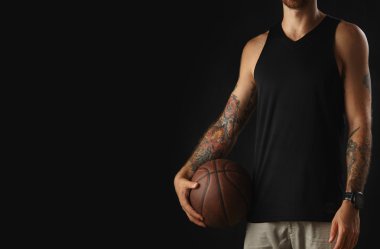 Acımasız dövmeli atlet deri basketbol topu tutar