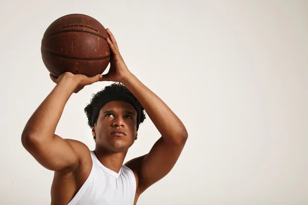 Young black athlete throwing basketball