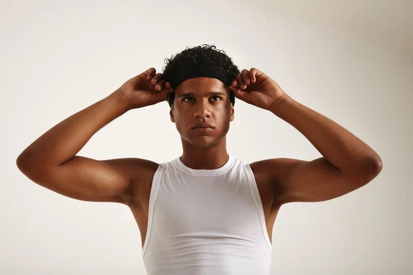Молодой чёрный баскетболист регулирует повязку на голове — стоковое фото