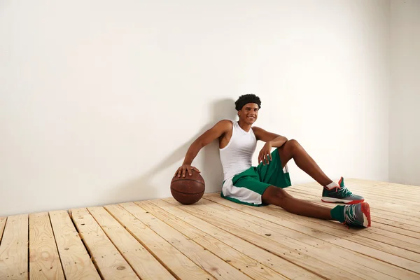 Jogador sentado no chão com bola — Fotografia de Stock