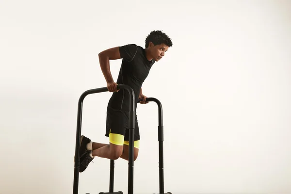 Чорний спортсмен робить стрибки на паралельних брусах — стокове фото