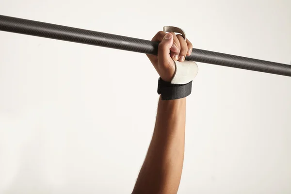 Hand of dark-skinned athlete grabbing pullup bar