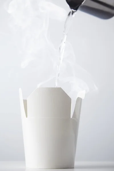 Boiling water poured into white ramen box — Stock Photo, Image