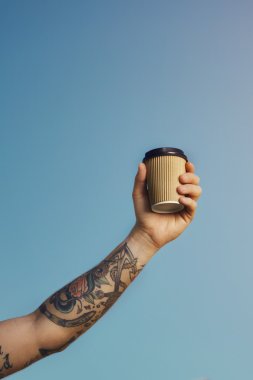 Dövmeli beyaz adam kağıt kahve fincanı tutar 