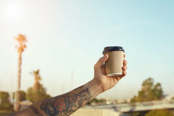 Mână de om tatuat cu ceașcă de cafea simplă bej — Fotografie, imagine de stoc