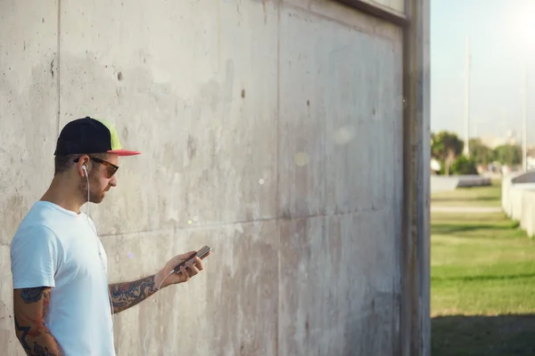 Hombre tatuado sosteniendo teléfono inteligente — Foto de Stock