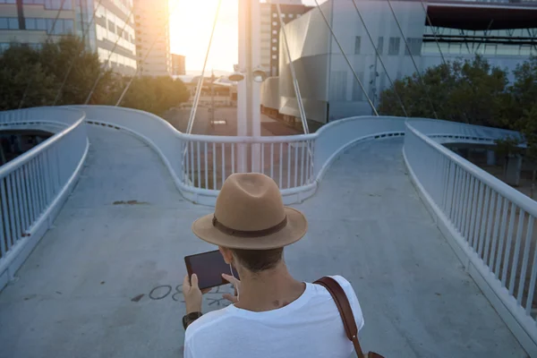 Man on pedestrian bridge with tablet — Stock Photo, Image