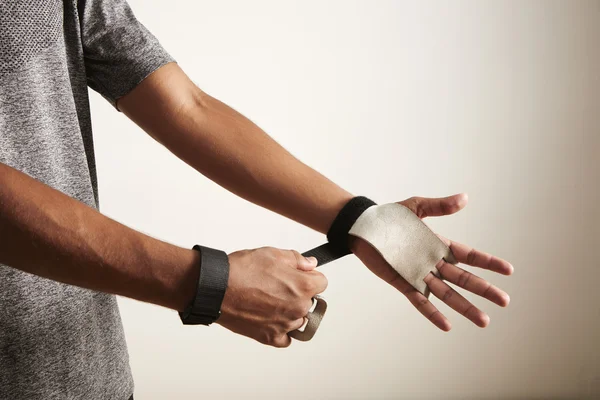 Athlete putting on cross fitness leather hand protectors — Stock Photo, Image