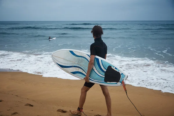 Surfista che cammina sulla riva con bordo — Foto Stock