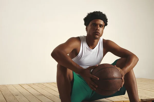 Гравець сидить на підлозі з м'ячем — стокове фото