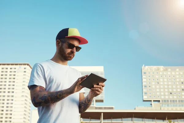 Barbudo joven buscando en tableta — Foto de Stock