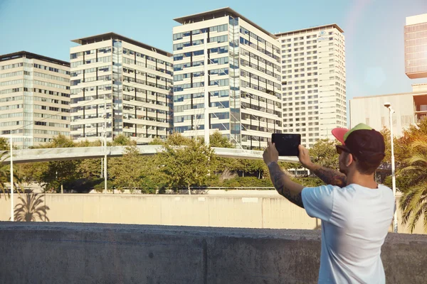 Jovem tirando fotos com tablet na cidade — Fotografia de Stock