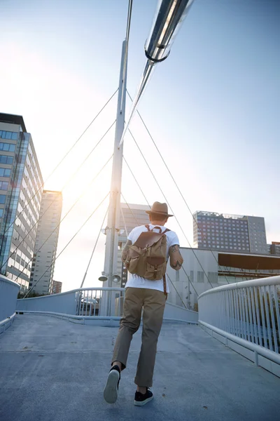 Mies kävelee pois jalankulkijoiden sillalla — kuvapankkivalokuva