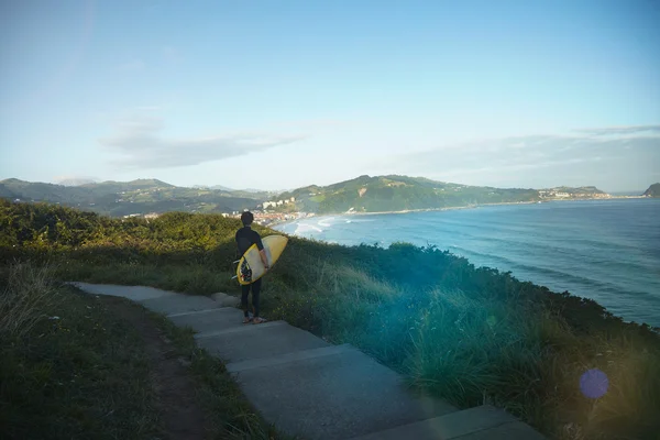 Surfista detém prancha de surf na montanha — Fotografia de Stock