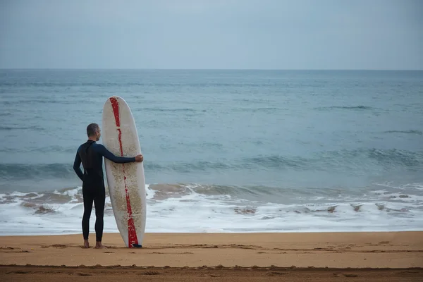 Surfer with longboard stays on beach — Stock Photo, Image