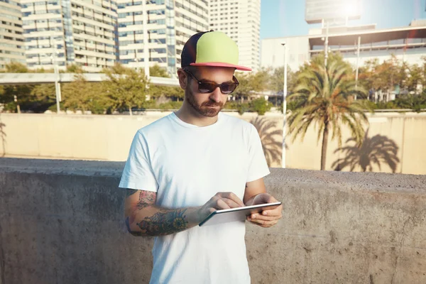 Tattooed bearded young man with tablet — Stock Photo, Image