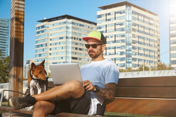 Hipster kannettavan tietokoneen, kahvia ja koira — kuvapankkivalokuva
